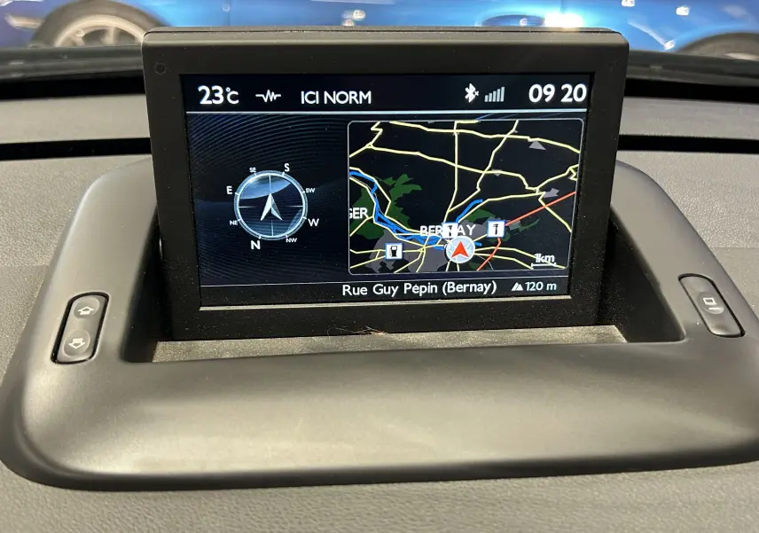 Écran GPS intégré au tableau de bord du Peugeot 3008 gris, affichant une carte et une boussole digitale.