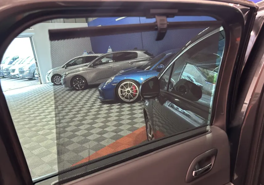 Vue partielle côté gauche du Peugeot 3008 gris, avec attelage et toit panoramique visibles depuis l'intérieur de la porte arrière.