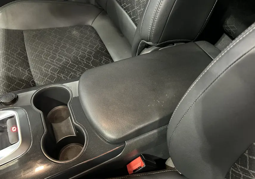 Gros plan intérieur sur l'accoudoir central noir et les sièges tissu gris foncé du Peugeot 3008 Ph.2 BlueHDi 120 Allure.