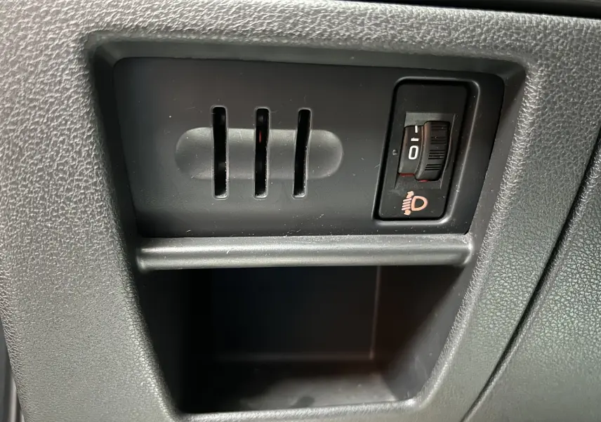 Gros plan sur le réglage d'inclinaison des phares dans l'habitacle du Peugeot 3008 gris.