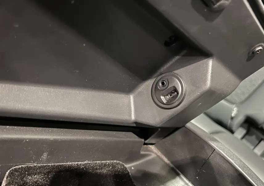Prise USB et auxiliaire dans la console centrale du Peugeot 3008 gris, vue en gros plan intérieur.