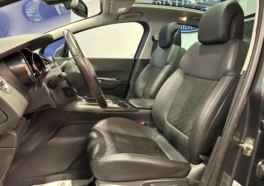 Vue intérieure côté conducteur du Peugeot 3008 gris, mettant en valeur les sièges en cuir et tissu avec toit panoramique visible.