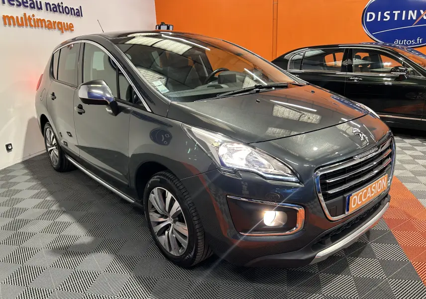 Peugeot 3008 gris en 3/4 avant droit, avec phares et antibrouillard allumés dans un showroom.