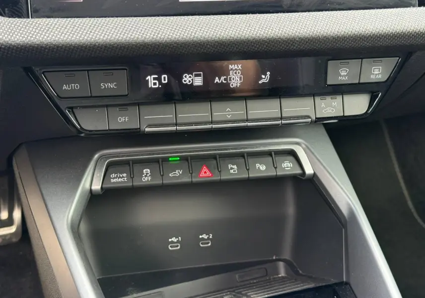 Vue rapprochée de la console centrale de l'Audi A3 Sportback 2025, avec commandes clim et ports USB visibles.