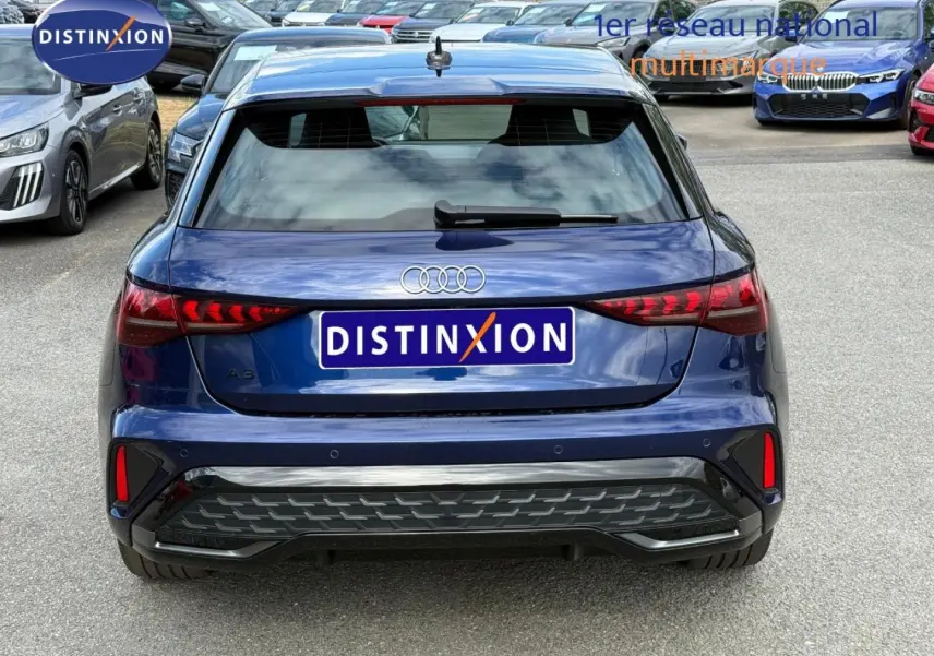 Vue arrière d'une Audi A3 Sportback 2025 bleu Navarre métallisé avec feux arrière LED et diffuseur noir.