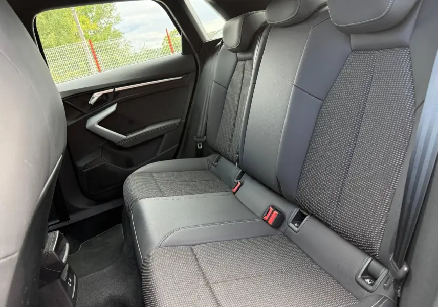 Vue latérale intérieure des sièges arrière en tissu noir et gris de l'Audi A3 Sportback 2025, version S line.