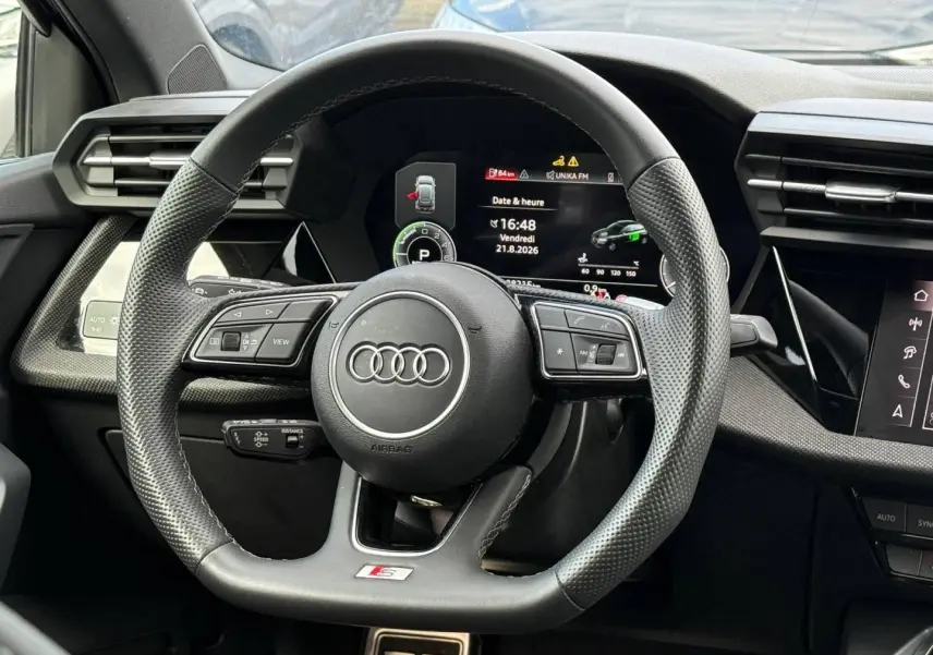 Vue rapprochée du volant sport Audi A3 Sportback 1.5 TFSI e 204ch S line avec tableau de bord numérique.