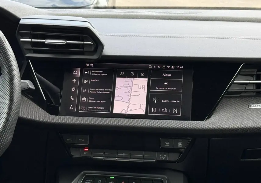 Vue rapprochée de la console centrale de l’Audi A3 Sportback 2025 avec écran tactile et commandes noires.