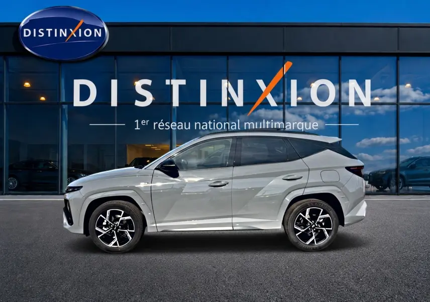 Hyundai Tucson 2026 gris shadow en profil droit, avec jantes alu noires et toit panoramique visible.