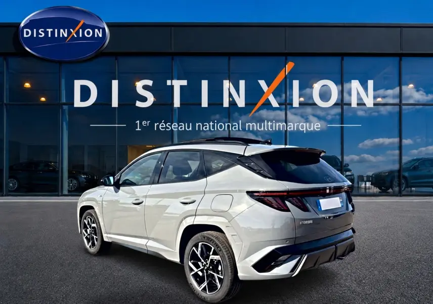 Vue 3/4 arrière droite du Hyundai Tucson 2026 gris shadow avec jantes alu et toit noir contrasté.