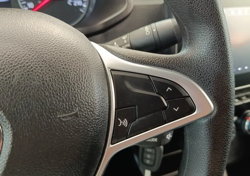 Gros plan sur le volant multifonctions noir du Renault Express 2023, avec commandes audio et finition argentée.