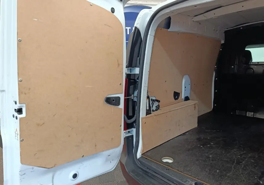 Vue intérieure arrière du Renault Express blanc 2023, montrant l'espace de chargement avec cloison pleine en bois.