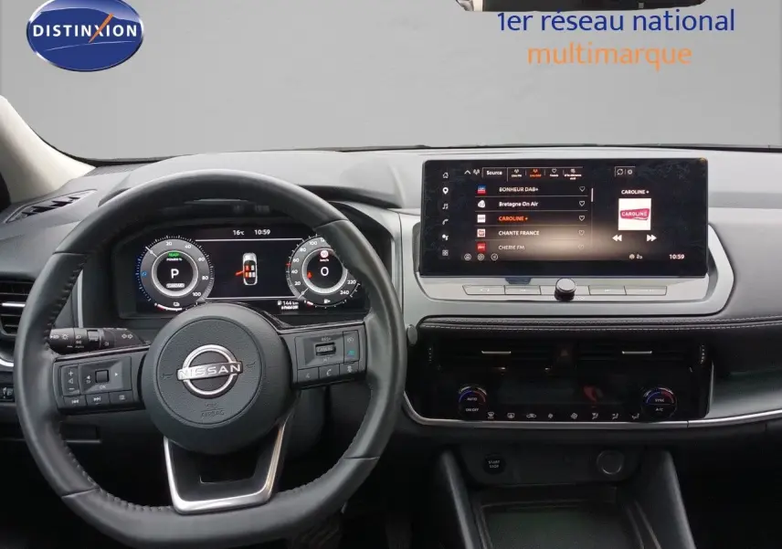 Vue intérieure du tableau de bord du Nissan Qashqai e-POWER 2025 avec volant noir et écran tactile central lumineux.