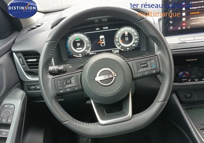 Vue rapprochée du volant cuir noir du Nissan Qashqai e-POWER 2025 avec tableau de bord numérique et écran central tactile.