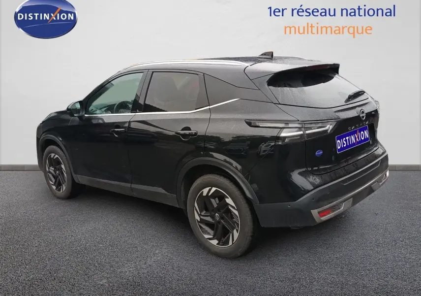 Vue 3/4 arrière côté gauche du Nissan Qashqai e-POWER 2025 noir Kuro Metal avec jantes stylisées et feux arrière LED fins.