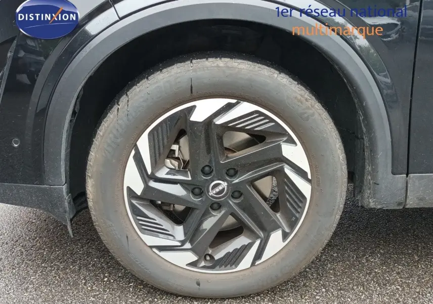 Gros plan sur la roue avant gauche noire Kuro Metal du Nissan Qashqai e-POWER 2025 avec jante au design moderne bicolore.