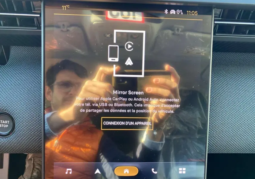 Écran tactile central du Citroën C5 Aircross 2026 affichant la connexion Apple CarPlay, avec reflet d'une personne.