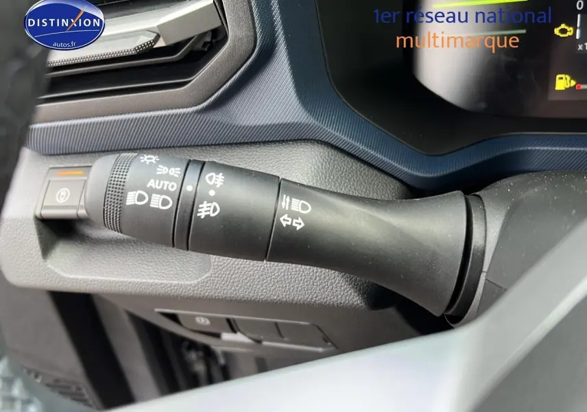 Gros plan sur la commande des feux et clignotants du tableau de bord du Dacia Duster gris schiste 2025.