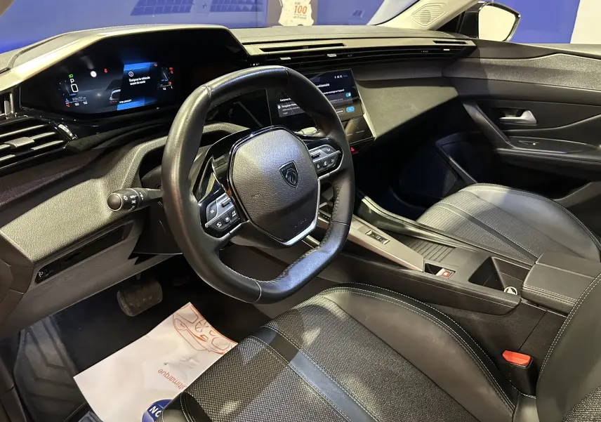 Vue intérieure côté conducteur de la Peugeot 308 2024, volant cuir noir et tableau de bord digital moderne.