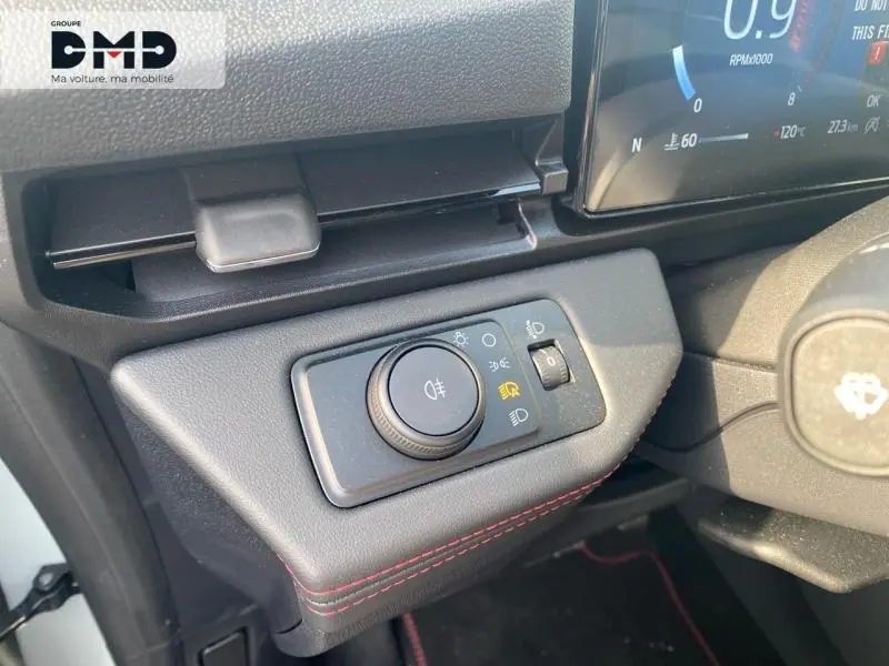 Gros plan sur la commande des phares dans l'habitacle gris avec surpiqûres rouges du Ford Puma 2026 côté gauche.