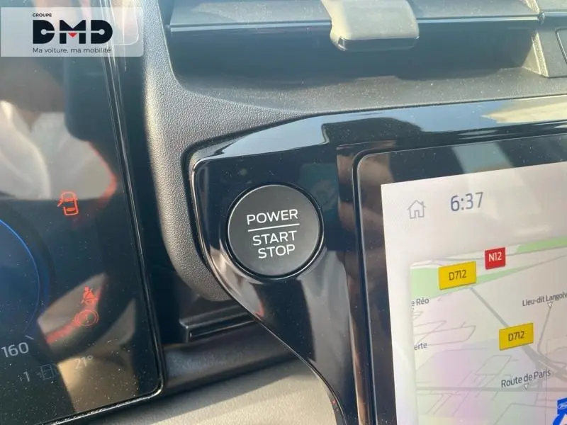 Gros plan sur le bouton Power Start Stop et l'écran tactile GPS du tableau de bord du Ford Puma gris.