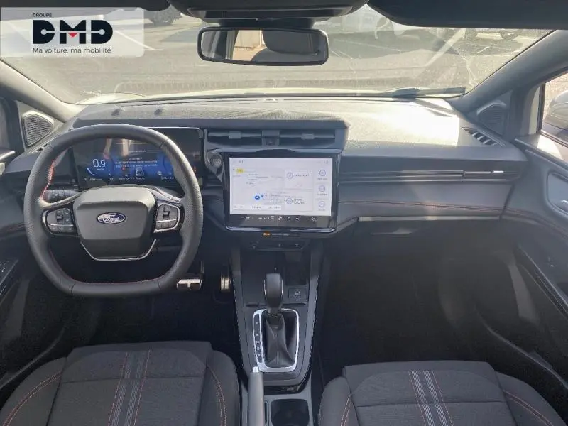 Vue intérieure avant du Ford Puma gris Cactus, volant multifonction, écran tactile central et sièges tissu avec surpiqûres rouges.