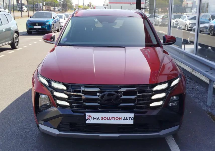 Vue de face du Hyundai Tucson 2024 en rouge Ultimate Métal, mettant en valeur sa calandre noire et ses feux LED distinctifs.
