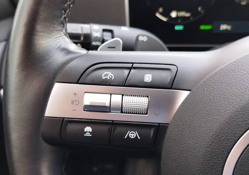Gros plan sur les commandes multifonctions côté gauche du volant du Hyundai Tucson 2024, finition Ultimate Red Métal.