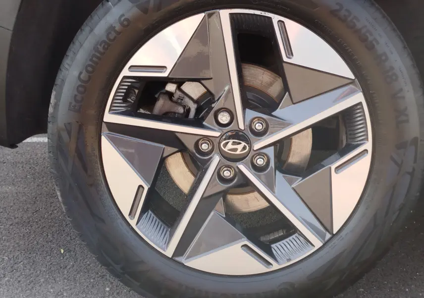 Gros plan sur la jante bi-ton noire et argentée avec logo Hyundai au centre, montée sur un pneu Continental.