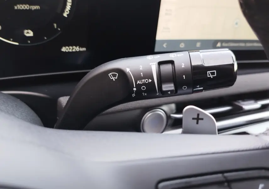 Gros plan sur la manette d’essuie-glace du Hyundai Tucson 2024, avec tableau de bord numérique en arrière-plan.