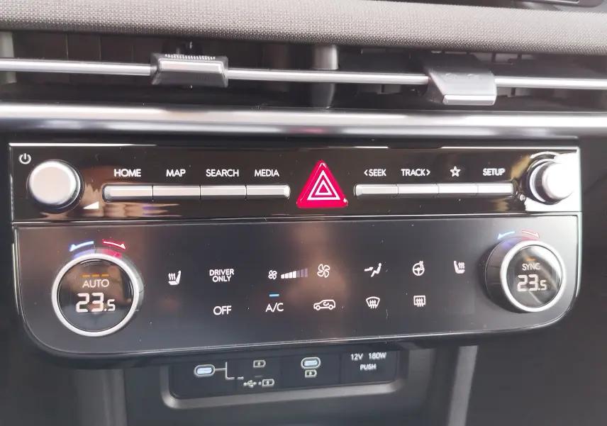 Vue rapprochée de la console centrale du Hyundai Tucson 2024, affichant les commandes de climatisation et multimédia.
