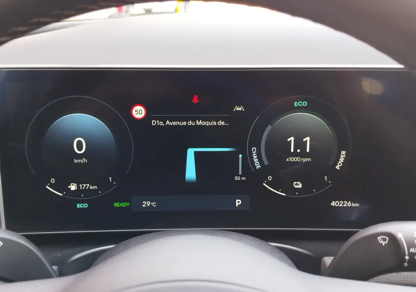Tableau de bord numérique du Hyundai Tucson 2024, affichant vitesse, autonomie et mode ECO, vu depuis le poste de conduite.