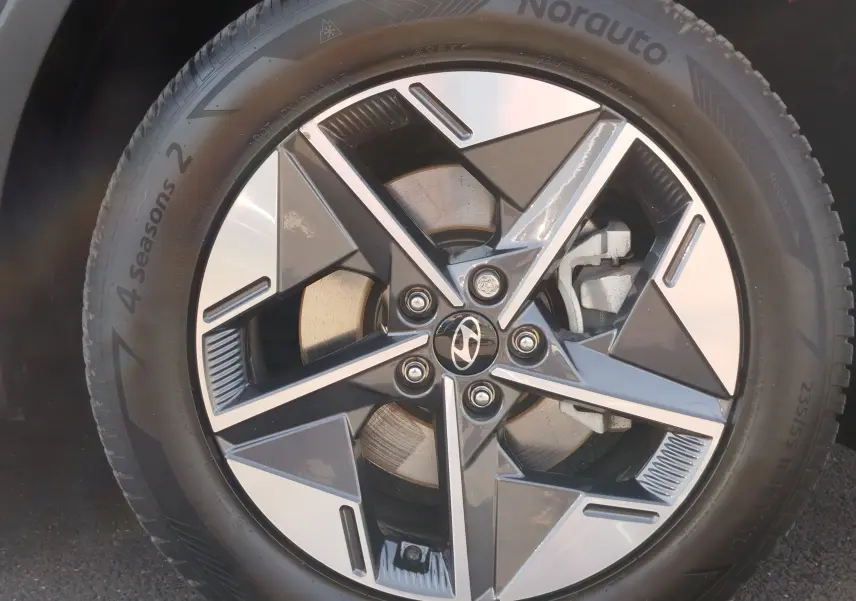 Gros plan sur la jante alliage bi-ton du Hyundai Tucson 2024, avec logo Hyundai au centre et pneu 4 Seasons visible.