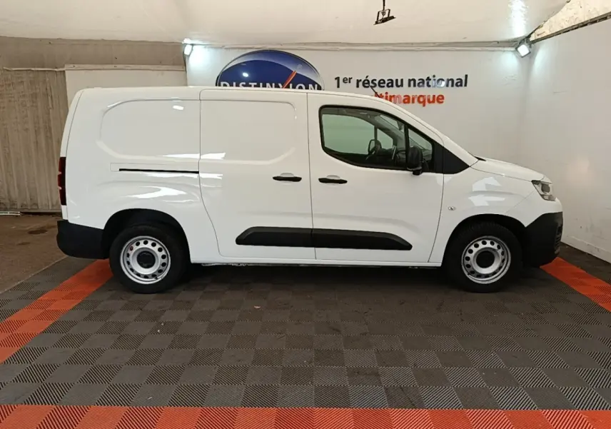 Vue de profil côté droit d'un utilitaire Citroën Berlingo XL blanc avec protections latérales noires et jantes acier.