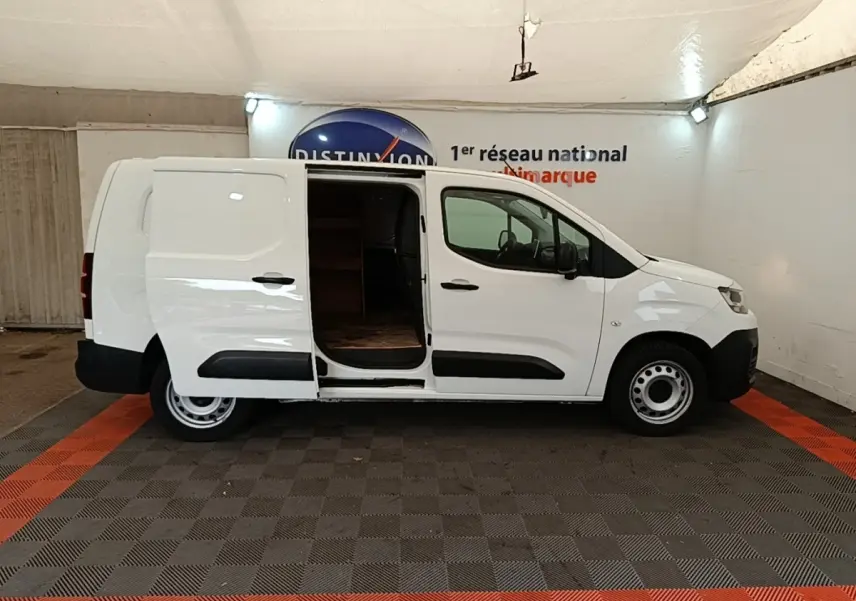 Vue de profil côté droit d’un Citroën Berlingo XL blanc 2020 avec porte latérale coulissante ouverte montrant l’intérieur vide.