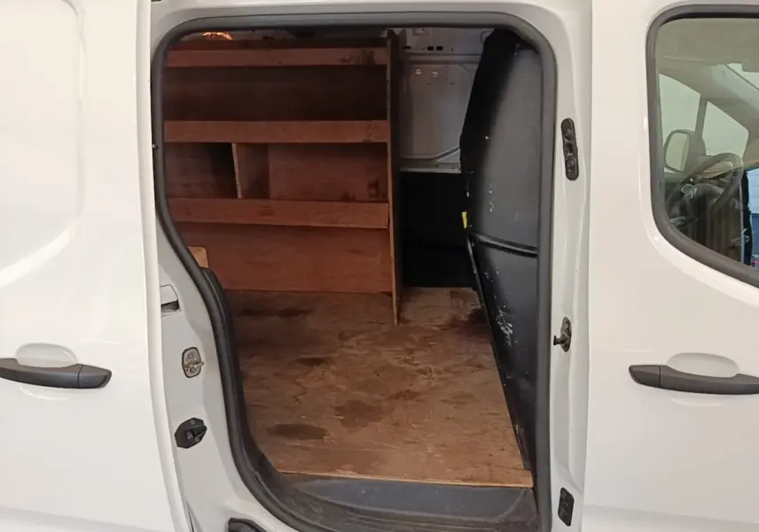 Vue latérale droite d’un Citroën Berlingo blanc 2020 avec porte coulissante ouverte montrant l’espace de chargement aménagé en bois.