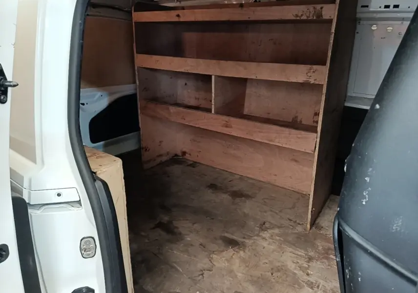 Vue intérieure arrière du Citroën Berlingo blanc 2020 avec aménagement bois de rangement dans l’espace de chargement.