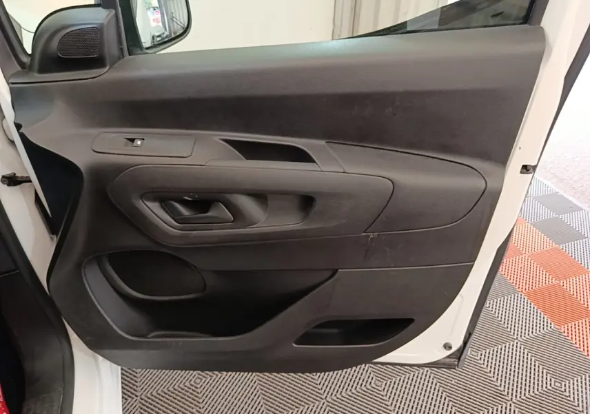 Vue intérieure de la porte avant gauche noire du Citroën Berlingo XL blanc de 2020, avec poignée intégrée.