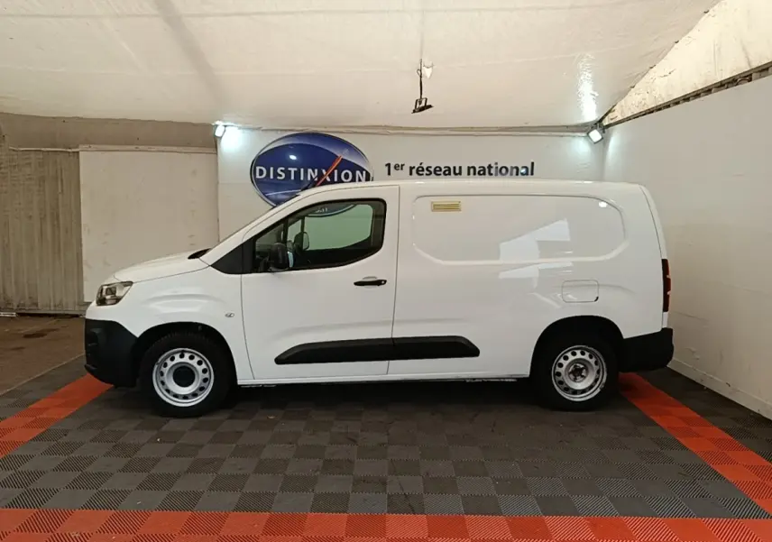 Vue de profil côté gauche d’un utilitaire Citroën Berlingo XL blanc avec jantes acier et protections noires sur les portes.