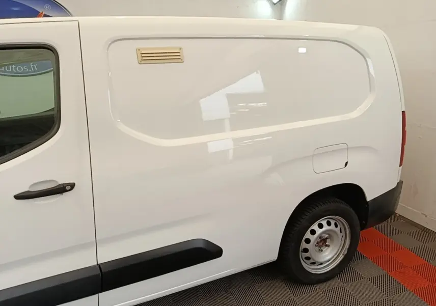 Vue de profil côté droit d'un utilitaire Citroën Berlingo XL blanc avec porte latérale pleine et jante acier.