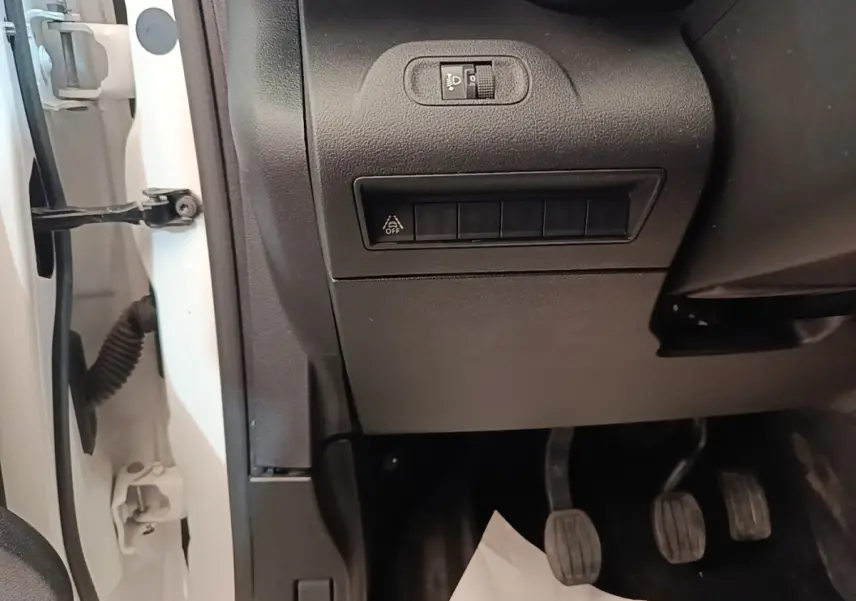 Détail intérieur côté conducteur du Citroën Berlingo XL blanc 2020, montrant les pédales et commandes sous le tableau de bord.