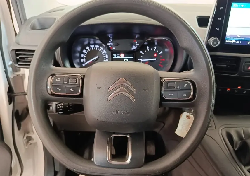 Vue rapprochée du volant multifonctions noir et du tableau de bord numérique du Citroën Berlingo XL blanc de 2020.