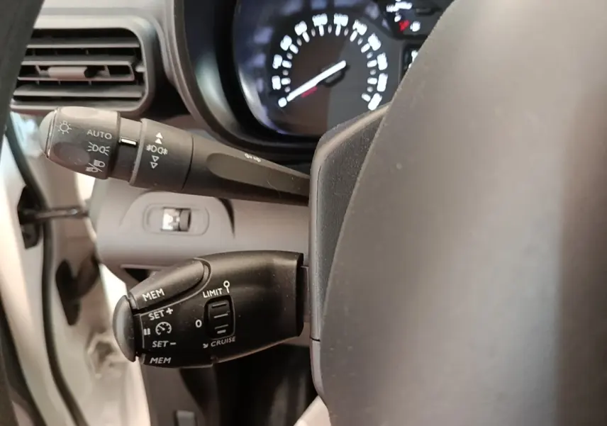 Gros plan sur la commande de régulateur de vitesse et limiteur, volant partiel de Citroën Berlingo blanc 2020.