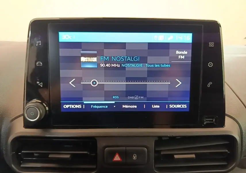 Écran tactile central du tableau de bord du Citroën Berlingo XL blanc, affichant la radio FM Nostalgie.