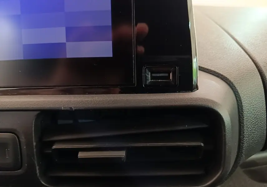 Gros plan sur la console centrale noire du Citroën Berlingo XL 2020, montrant l'écran tactile et une sortie d'air.
