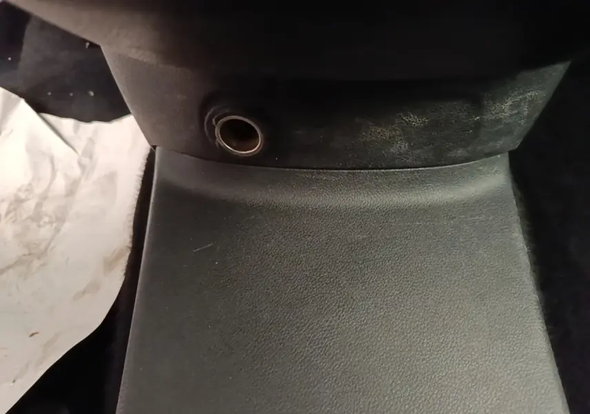 Gros plan sur la prise 12V noire située à la base de la console centrale intérieure du Citroën Berlingo blanc.