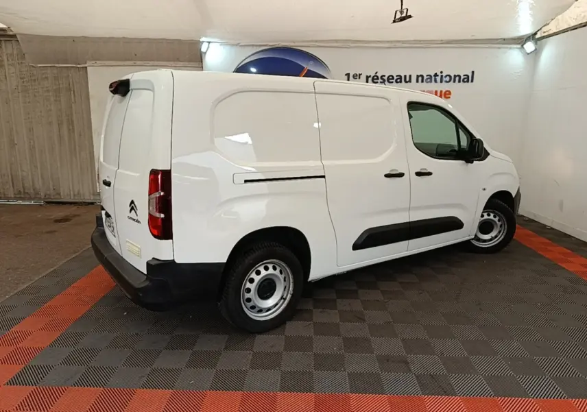Vue 3/4 arrière droite d’un Citroën Berlingo XL blanc avec jantes acier et protections latérales noires.