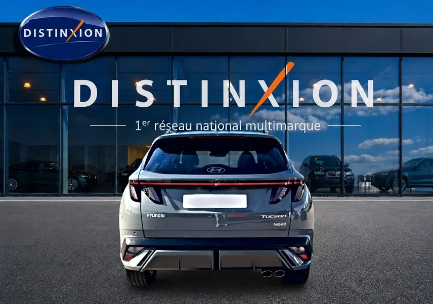 Vue arrière d’un Hyundai Tucson gris shadow hybride 2026, avec feux LED et double sortie d’échappement visible.