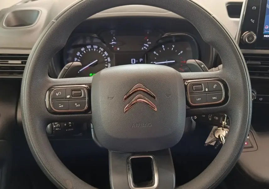 Vue rapprochée du volant multifonctions noir du Citroën Berlingo 2020 avec tableau de bord et écran tactile visibles.