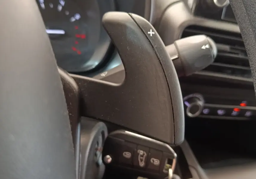 Gros plan sur la palette de changement de vitesse au volant du Citroën Berlingo blanc, intérieur noir.